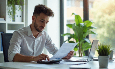 Jeune professionnel analysant ses fiches de paie au bureau
